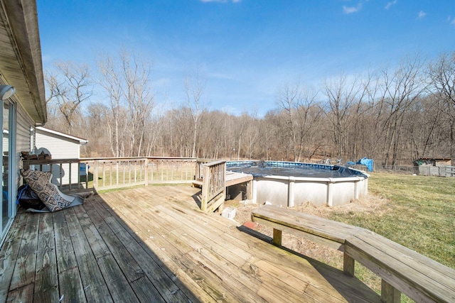 deck with a yard, fence, and an outdoor pool