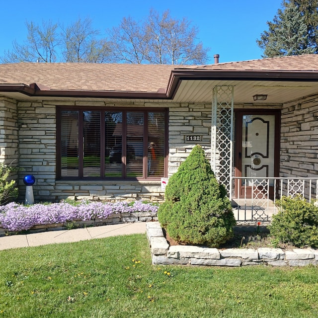 property entrance with stone siding and a shingled roof