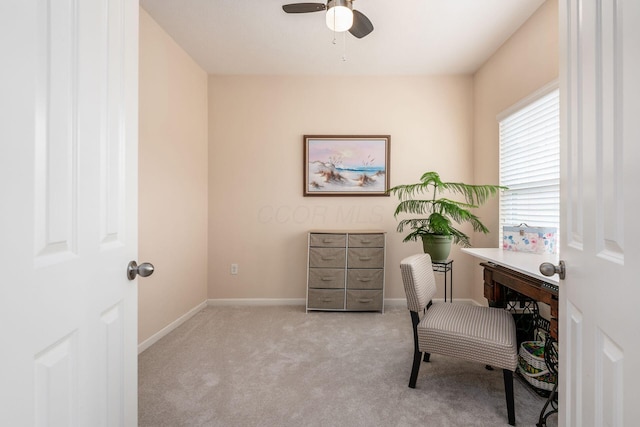 carpeted office space with ceiling fan and baseboards