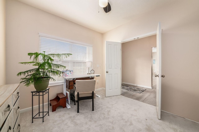 carpeted office with vaulted ceiling, a ceiling fan, and baseboards