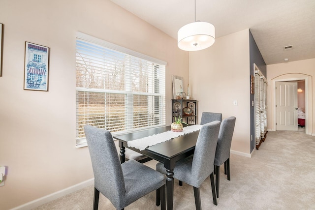 dining room featuring visible vents, baseboards, and light colored carpet