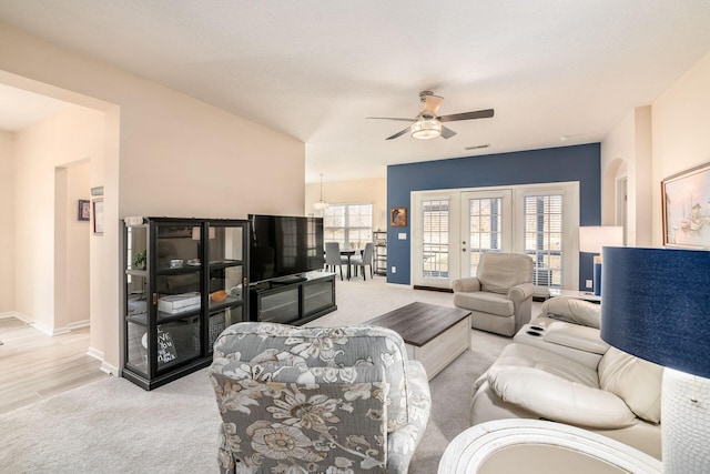 living area featuring visible vents, carpet flooring, a ceiling fan, and baseboards