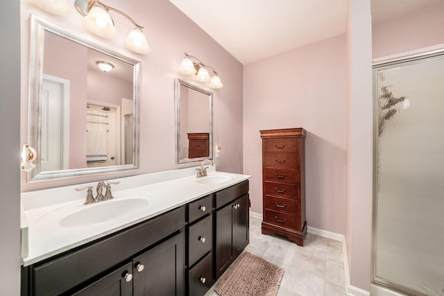 bathroom with baseboards, double vanity, a sink, and a shower stall