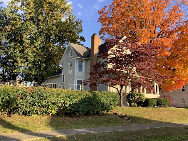 view of side of property featuring a yard and a chimney