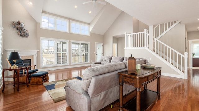 living room with a glass covered fireplace, wood-type flooring, and plenty of natural light