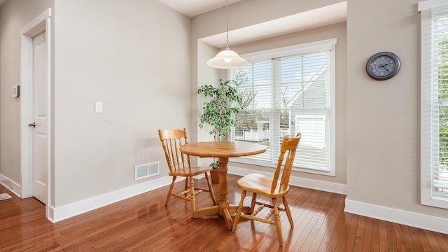 dining area featuring wood-type flooring, visible vents, and baseboards