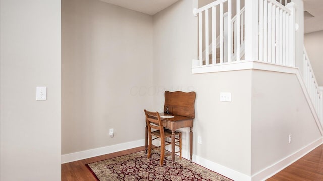 living area with baseboards and wood finished floors