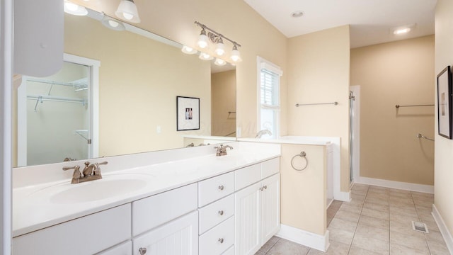 full bathroom featuring double vanity, a sink, baseboards, and tile patterned floors