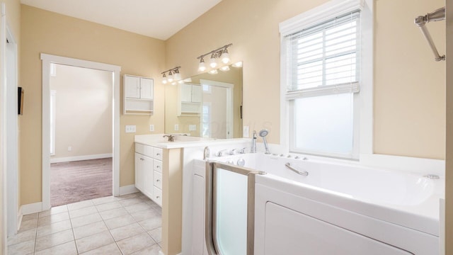 full bath featuring baseboards, vanity, a bath, and tile patterned floors