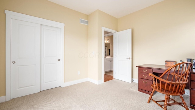 office space with baseboards, visible vents, and light colored carpet