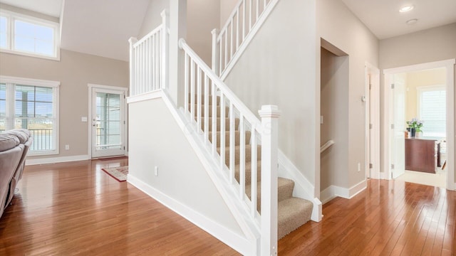 staircase featuring a wealth of natural light, recessed lighting, baseboards, and hardwood / wood-style flooring