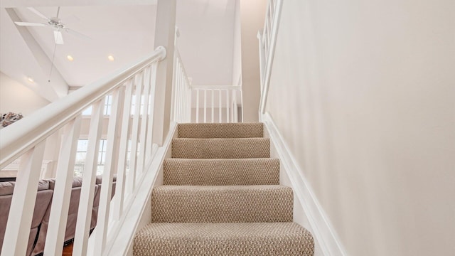 stairway featuring a ceiling fan