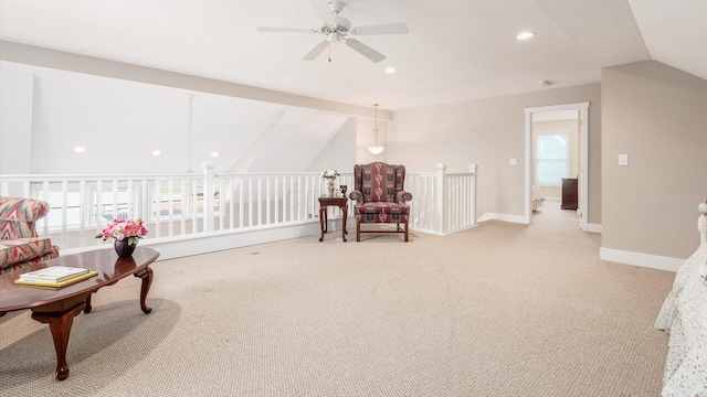 living area featuring lofted ceiling, plenty of natural light, light carpet, and baseboards