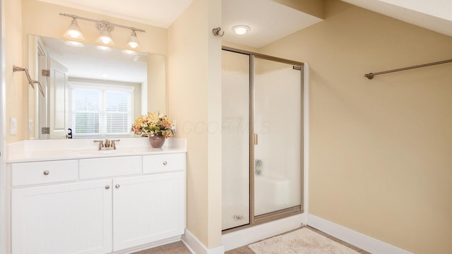 bathroom with a shower stall, vanity, and baseboards