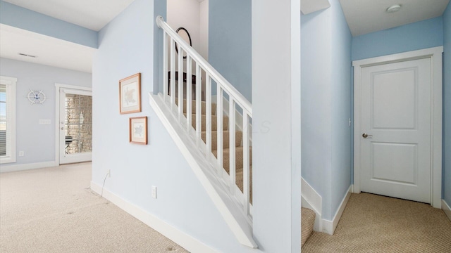 stairs with carpet, visible vents, and baseboards