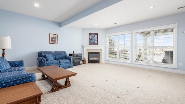 carpeted living area featuring baseboards, beamed ceiling, a glass covered fireplace, and recessed lighting