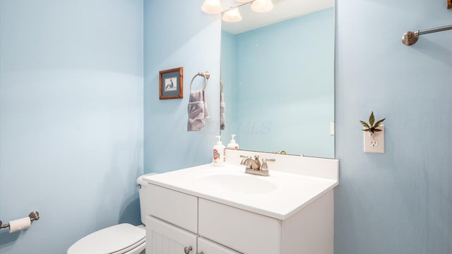 half bathroom with toilet and vanity