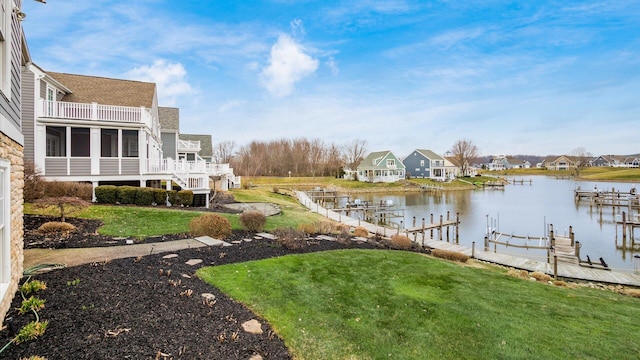 exterior space with a water view, a sunroom, a boat dock, a balcony, and a residential view