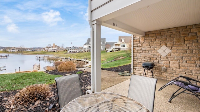 view of patio with outdoor dining area and a water view