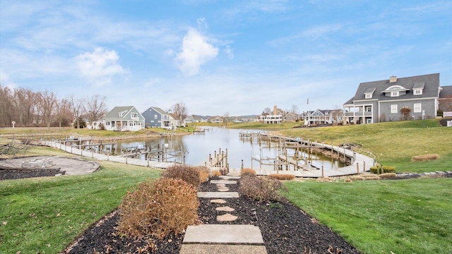 dock area with a residential view, a water view, and a yard