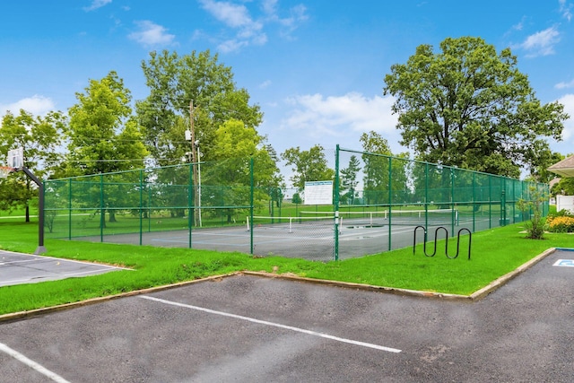 view of sport court with a yard and fence