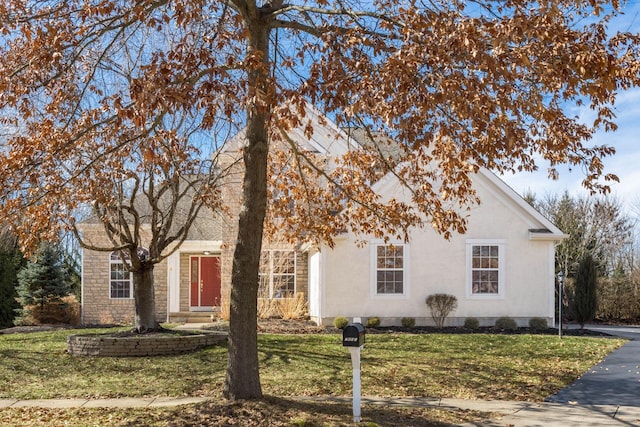 view of front facade with a front yard and stucco siding