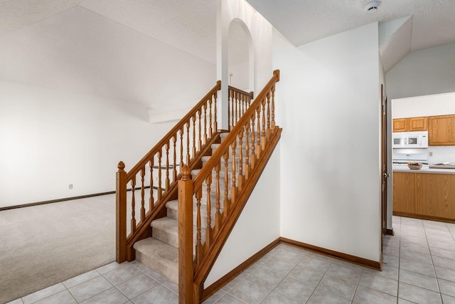 stairway with carpet, baseboards, a textured ceiling, and tile patterned floors