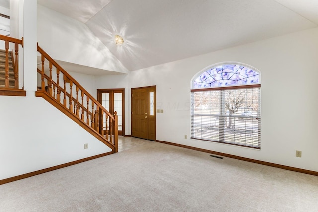 entrance foyer featuring lofted ceiling, carpet, stairs, and baseboards