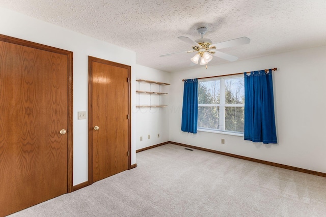 unfurnished bedroom featuring carpet, baseboards, and a textured ceiling