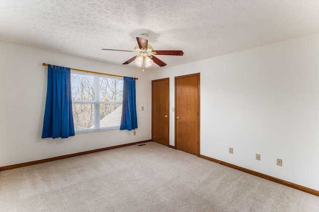 unfurnished bedroom featuring a textured ceiling, carpet flooring, two closets, and baseboards