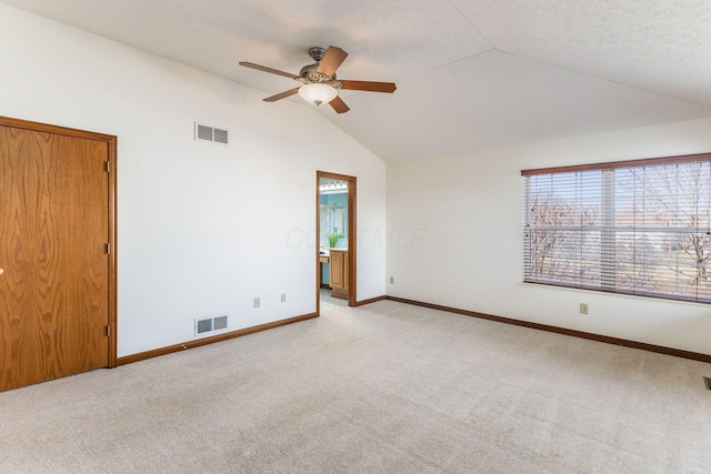 unfurnished room featuring lofted ceiling, visible vents, and light carpet