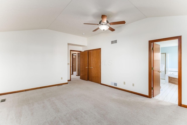 unfurnished bedroom with lofted ceiling, light carpet, and visible vents