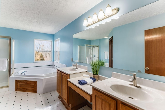 bathroom featuring vanity, a shower stall, a textured ceiling, and a bath