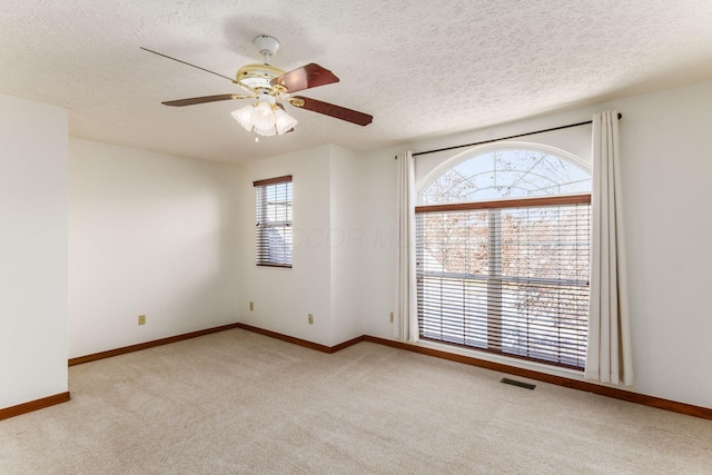 unfurnished room with light carpet, ceiling fan, visible vents, and baseboards