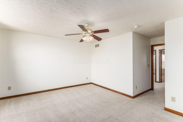 unfurnished room featuring baseboards, a ceiling fan, visible vents, and light colored carpet