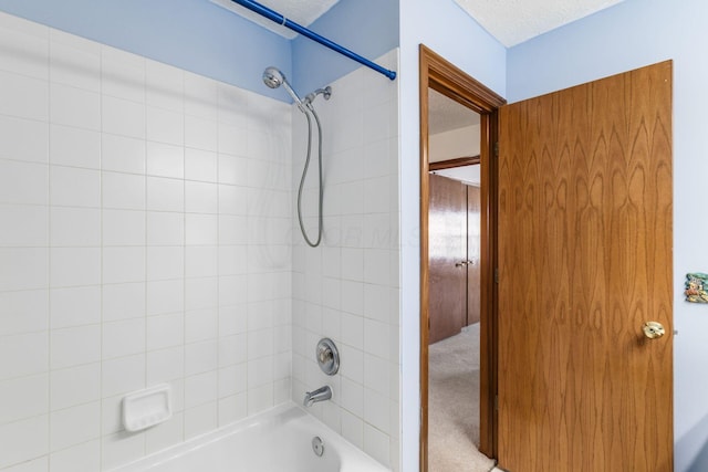 bathroom featuring a textured ceiling and bathtub / shower combination