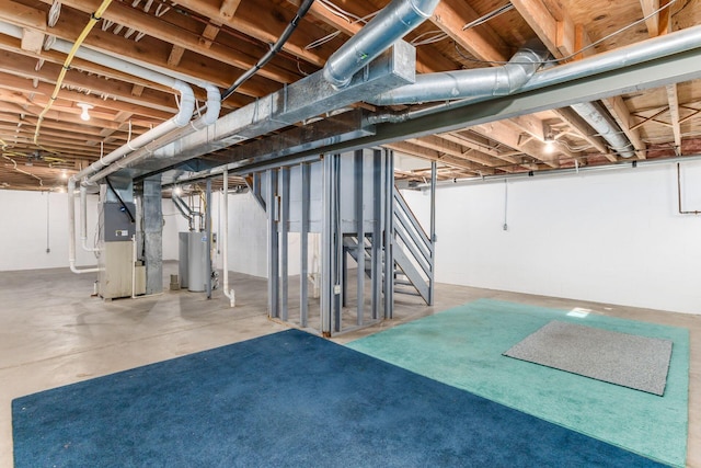 unfinished basement featuring water heater and heating unit