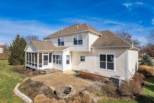 back of house featuring a patio, a shingled roof, a sunroom, a lawn, and stucco siding