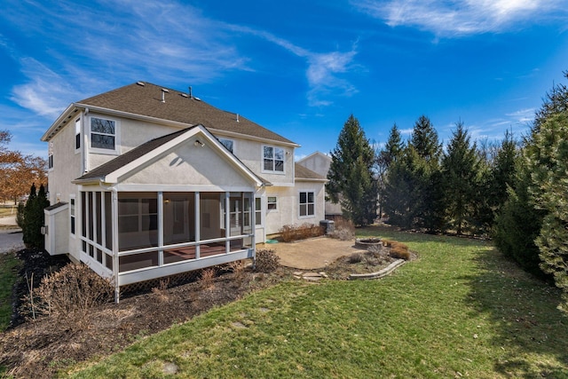 rear view of property featuring a lawn, a patio area, a sunroom, and stucco siding