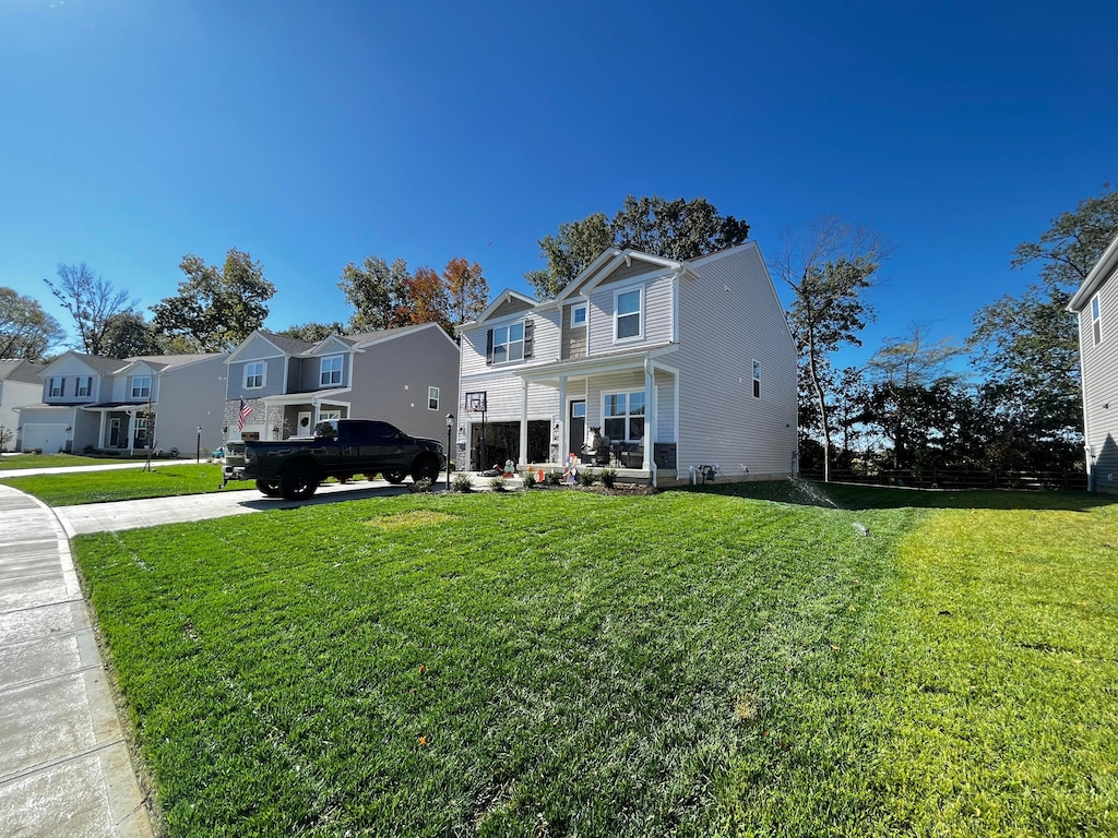 traditional-style house featuring a front yard and a residential view