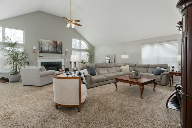 carpeted living area with a ceiling fan, high vaulted ceiling, and a tiled fireplace