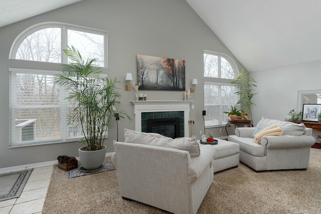 living room featuring high vaulted ceiling, a tile fireplace, tile patterned flooring, and baseboards