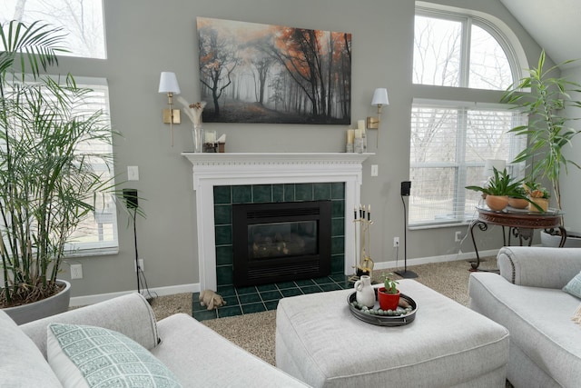 living room with lofted ceiling, baseboards, and a tiled fireplace