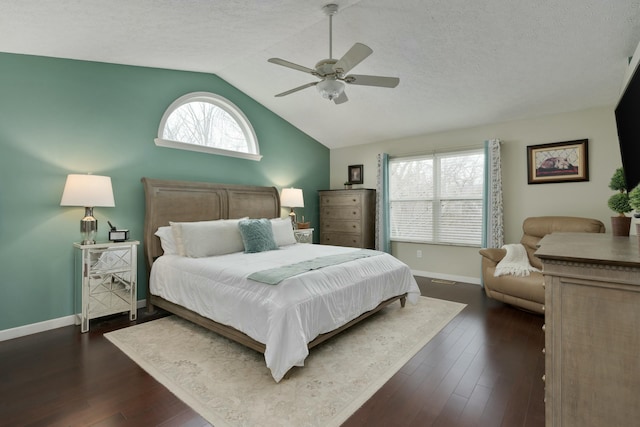 bedroom with dark wood-style flooring, multiple windows, vaulted ceiling, and a textured ceiling