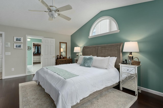 bedroom with lofted ceiling, a walk in closet, baseboards, and wood finished floors