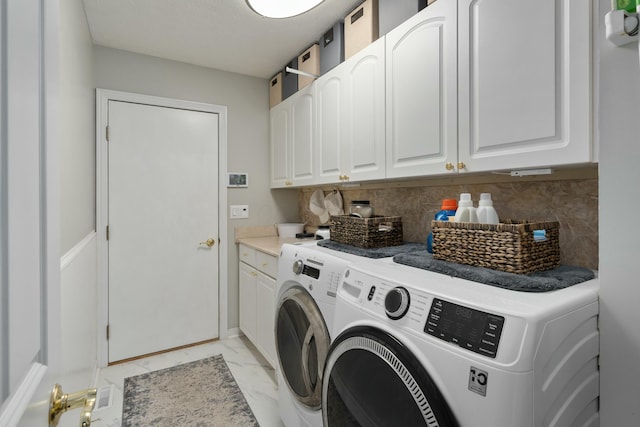 clothes washing area featuring marble finish floor, cabinet space, and independent washer and dryer