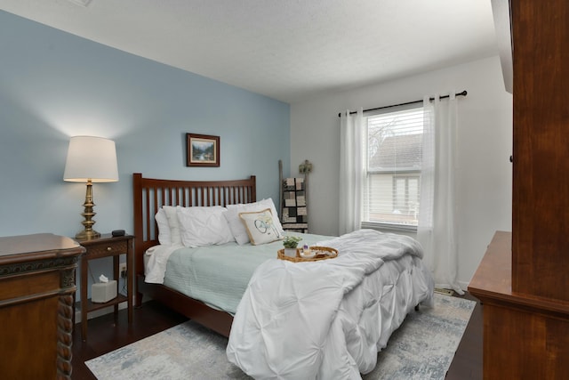 bedroom with a textured ceiling and wood finished floors