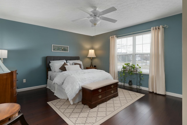 bedroom with ceiling fan, a textured ceiling, baseboards, and wood finished floors