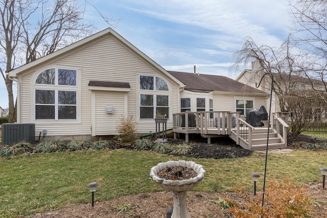 back of house with a deck, a yard, and central air condition unit