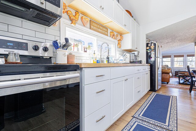 127 Brads Way, Russells Point, OH 43348 - kitchen with stainless steel appliances, tasteful backsplash, white cabinets, and light wood-style floors